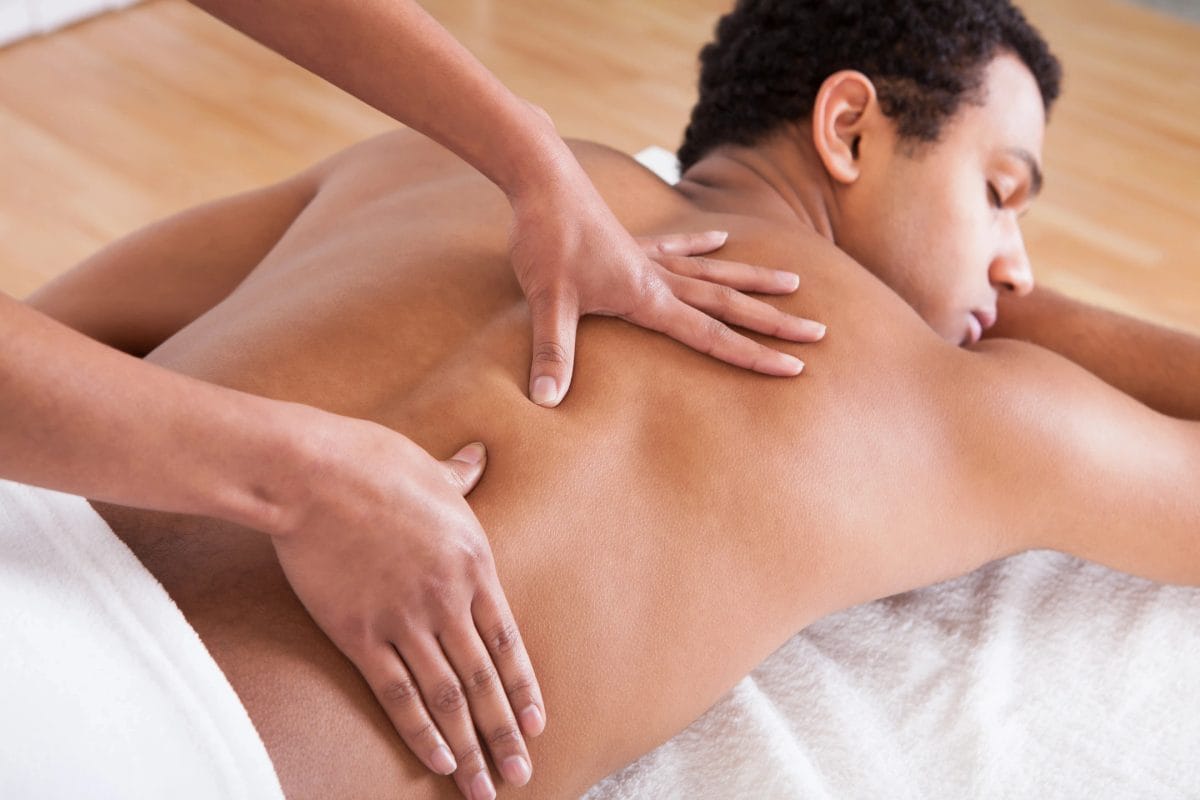 A therapist working with both hands along a client's back