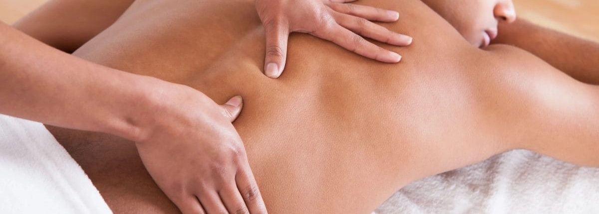 A certified therapist working with both hands along a client's back